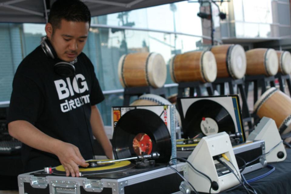 Masaki Miyagawa places the needle on a record during his DJ set before the Kinnara Taiko performance
